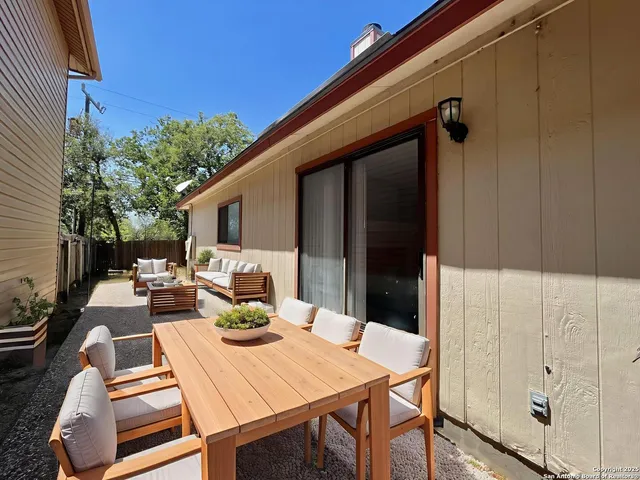 a view of a patio with table and chairs with wooden floor and fence