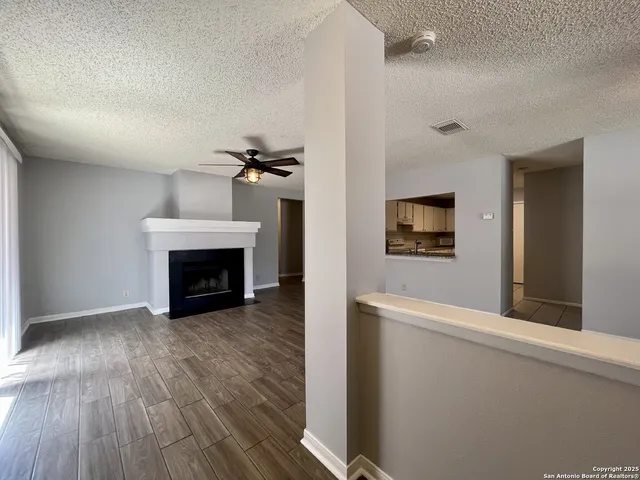 a view of a livingroom with a fireplace and a ceiling fan