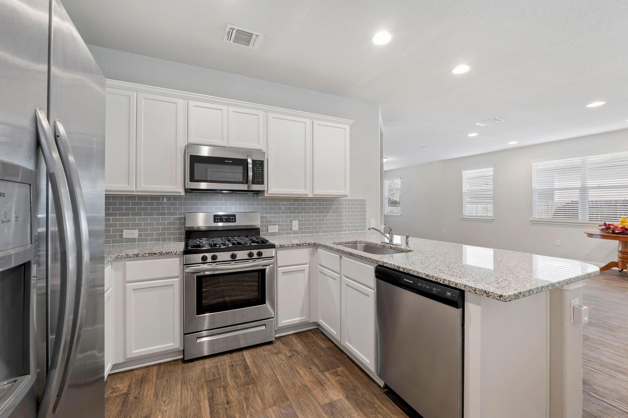 14409 Frankel Loop, Unit 33A Pflugerville, TX 78660 - Photo 13 of 28 a kitchen with granite countertop stainless steel appliances a stove sink and microwave