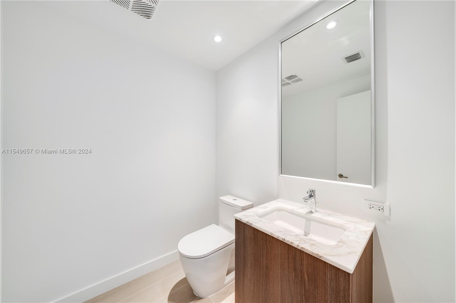 500 Alton Road, Unit 1806 Miami Beach, FL 33139 - Photo 4 of 8 a bathroom with a sink a toilet and a mirror