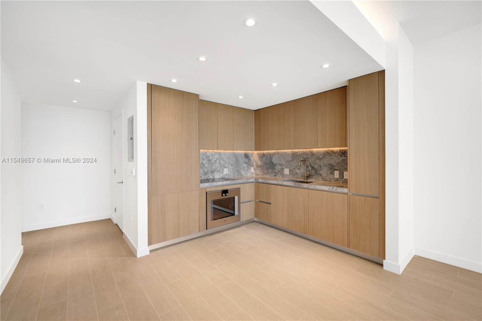 500 Alton Road, Unit 1806 Miami Beach, FL 33139 - Photo 6 of 8 a kitchen with granite countertop white cabinets and white appliances
