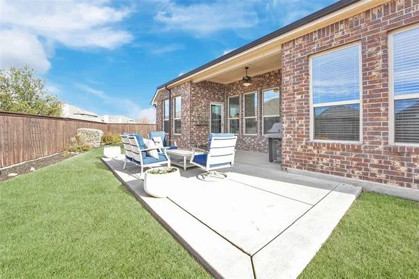 a view of a house with backyard and sitting area
