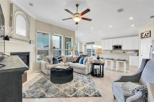 a living room with furniture a fireplace and a chandelier