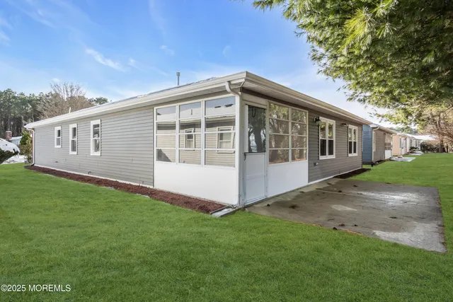 a view of a house with potted plants and a yard chair