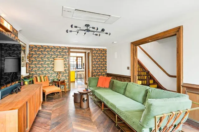 a living room with furniture stairs and a flat screen tv