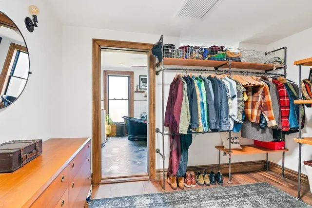 a view of walk in closet with clothes and shoes