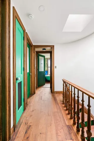 a view of a hallway with wooden floor and entryway