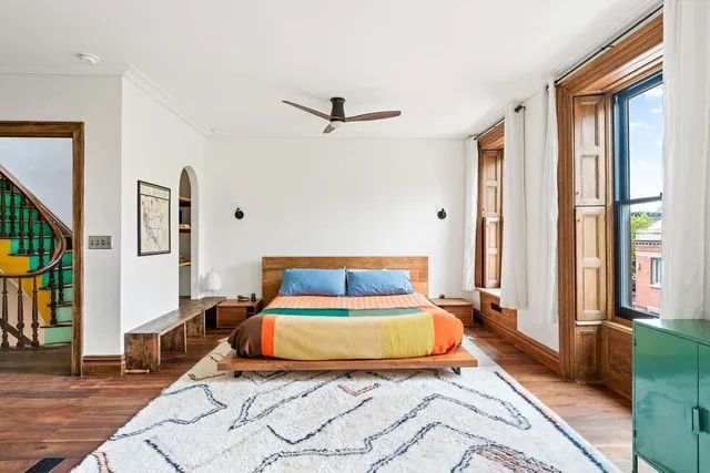 a bedroom with a bed and wooden floor