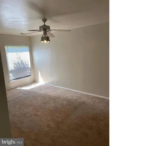 a view of a livingroom with a ceiling fan and window
