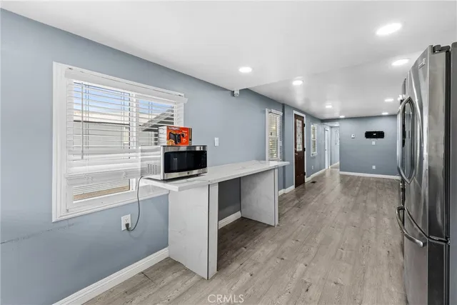 a kitchen with white cabinets and refrigerator