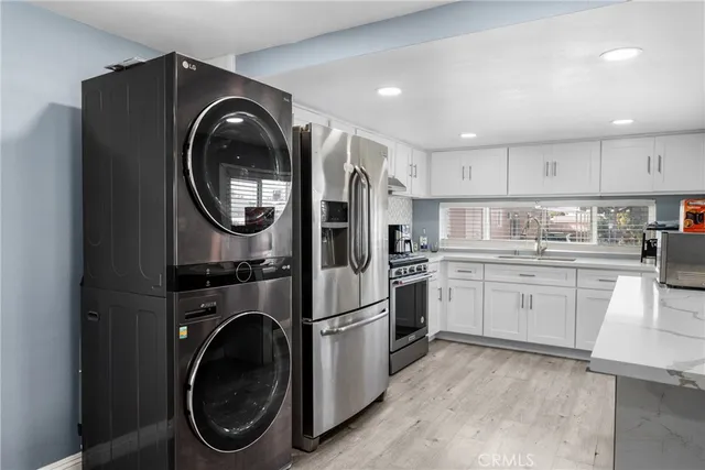 a kitchen with cabinets washer and dryer