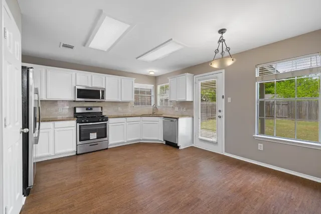 a kitchen with stainless steel appliances a refrigerator sink and microwave
