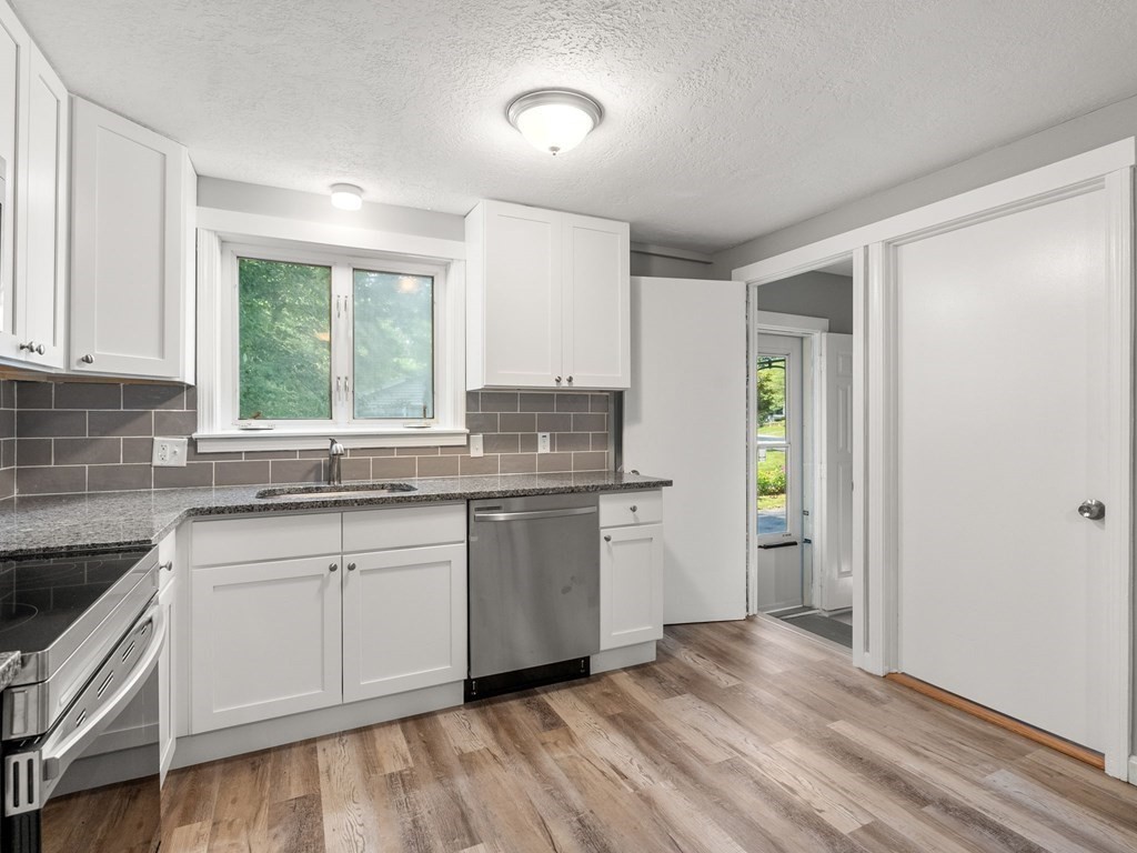 40 Dennis Street Springfield, MA 01118 - Photo 3 of 19 a kitchen with granite countertop cabinets stainless steel appliances and a window