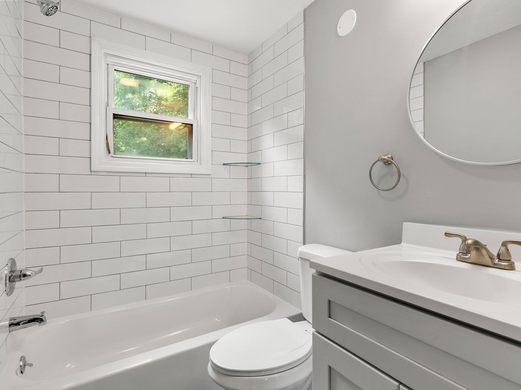 40 Dennis Street Springfield, MA 01118 - Photo 9 of 19 a bathroom with a bathtub sink vanity mirror and toilet