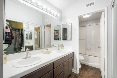 a bathroom with a double vanity sink mirror and toilet