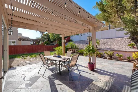 a view of a patio with table and chairs with wooden floor and plants