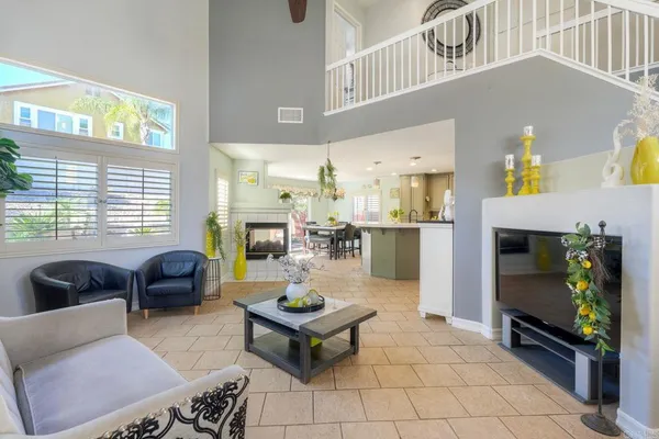a living room with furniture a fireplace and a chandelier