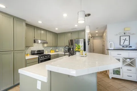 a kitchen with stainless steel appliances kitchen island sink stove and refrigerator