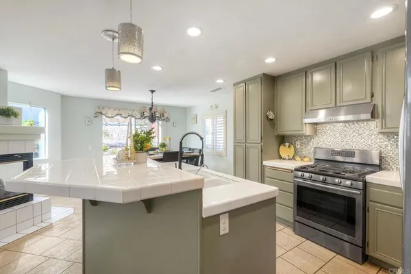 a kitchen with stainless steel appliances a sink stove and cabinets