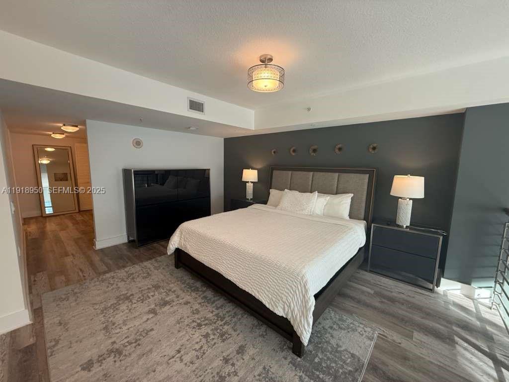 41 Southeast 5th Street, Unit 708 Miami, FL 33131 - Photo 15 of 29 a spacious bedroom with a bed and a fireplace