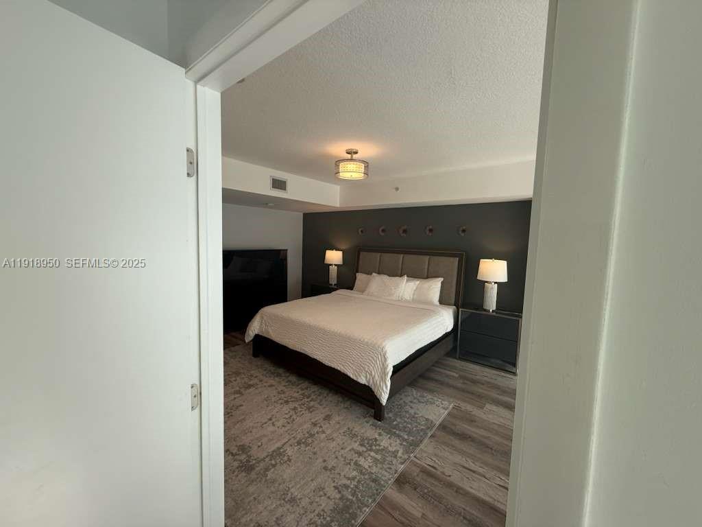 41 Southeast 5th Street, Unit 708 Miami, FL 33131 - Photo 16 of 29 a bedroom with a bed and a night stand