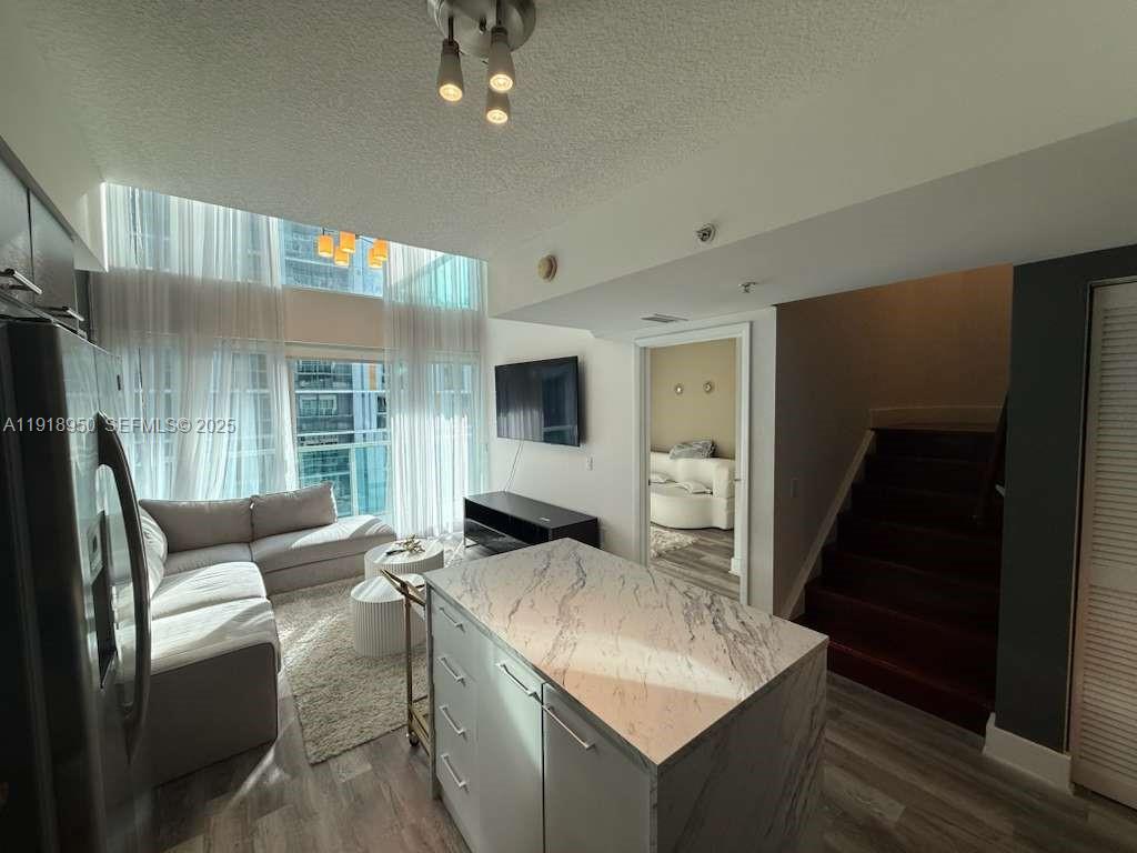 41 Southeast 5th Street, Unit 708 Miami, FL 33131 - Photo 2 of 29 a living room with furniture and a flat screen tv