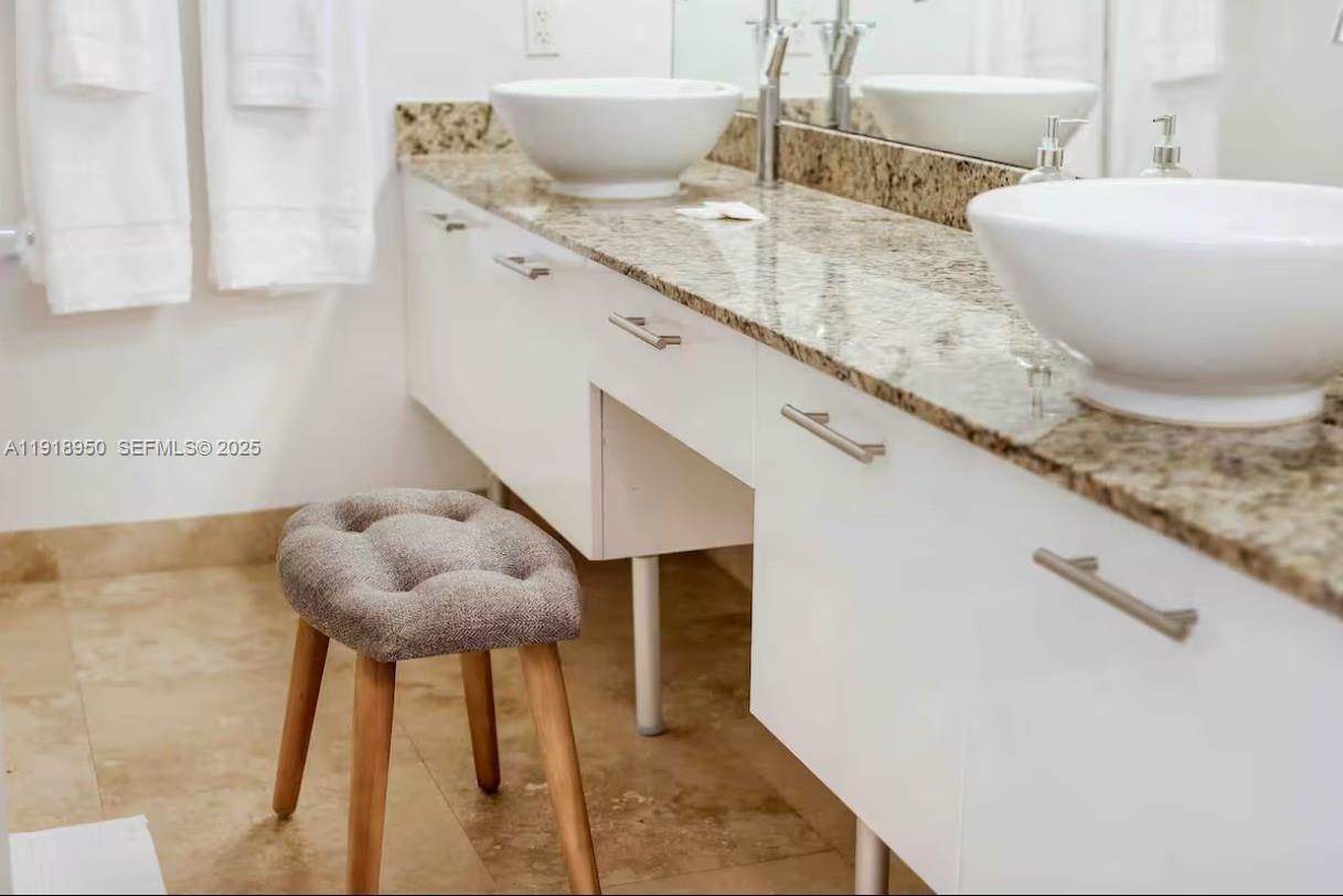 41 Southeast 5th Street, Unit 708 Miami, FL 33131 - Photo 23 of 29 a bathroom with a granite countertop sink and a mirror