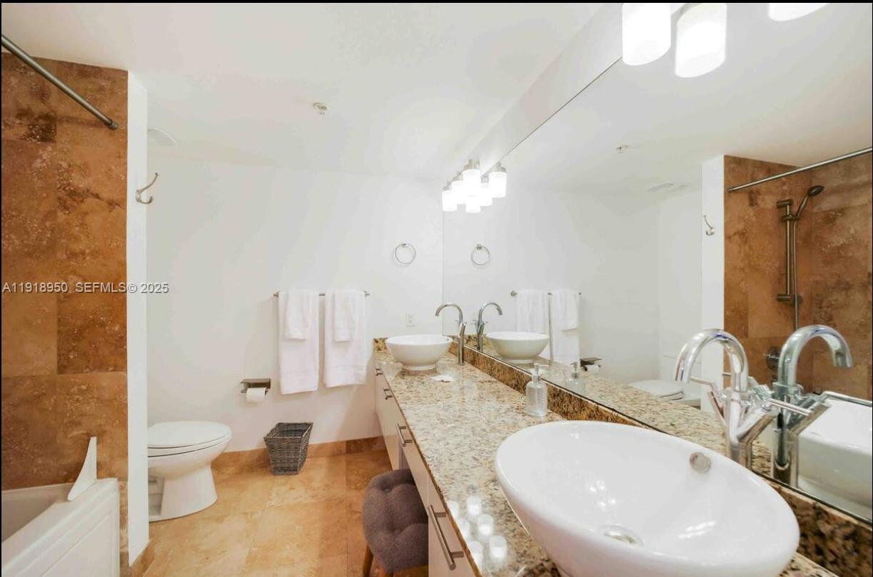 41 Southeast 5th Street, Unit 708 Miami, FL 33131 - Photo 24 of 29 a bathroom with a double vanity sink toilet and shower
