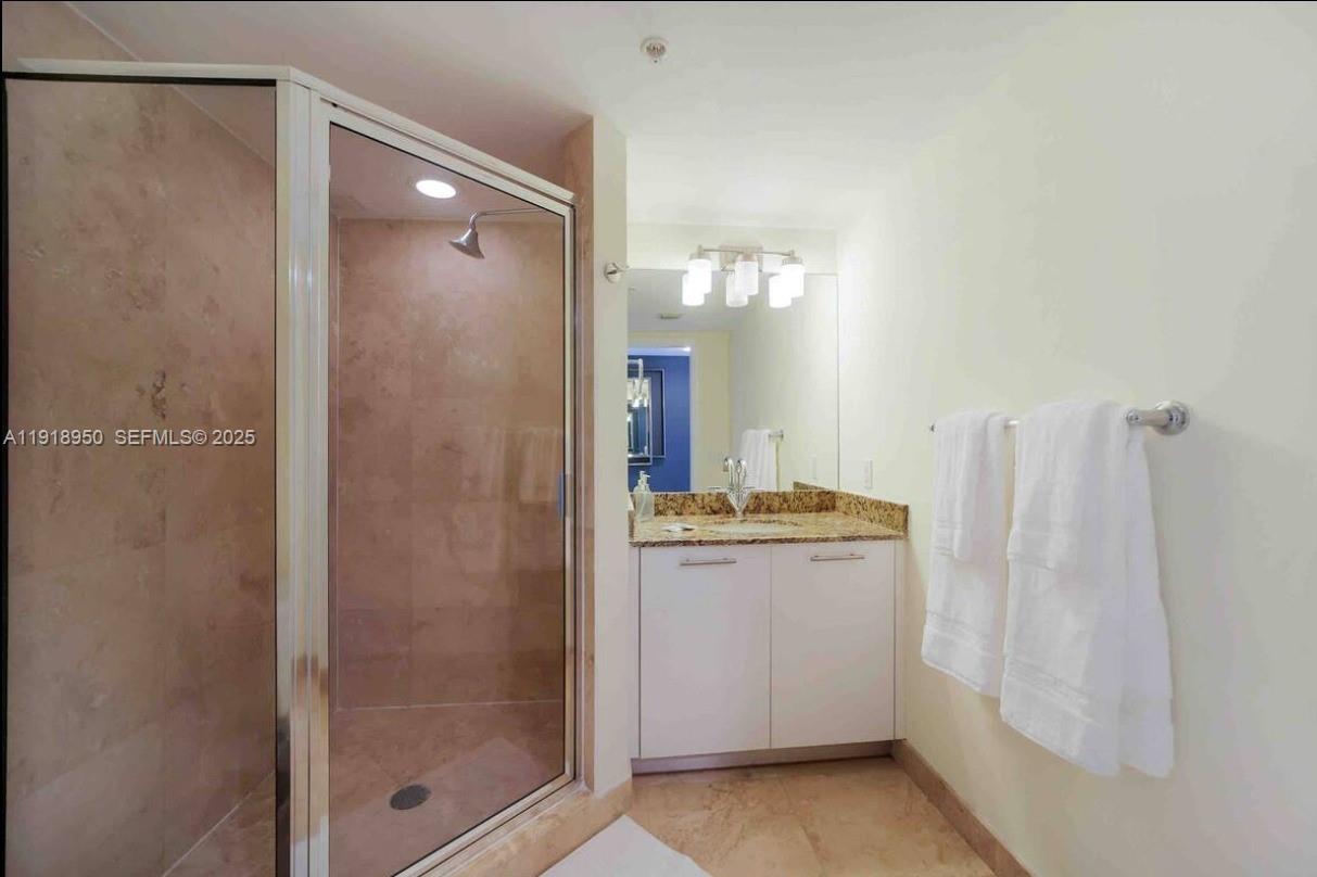 41 Southeast 5th Street, Unit 708 Miami, FL 33131 - Photo 25 of 29 a bathroom with a granite countertop shower and a sink