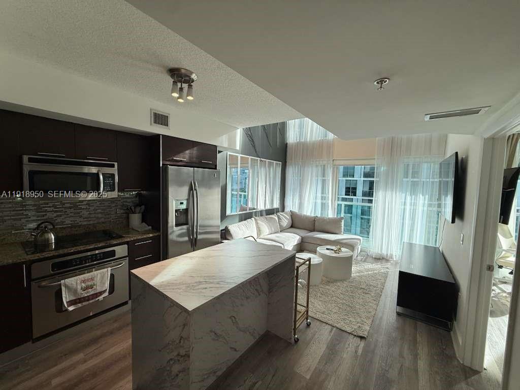 41 Southeast 5th Street, Unit 708 Miami, FL 33131 - Photo 3 of 29 a kitchen with sink refrigerator and microwave