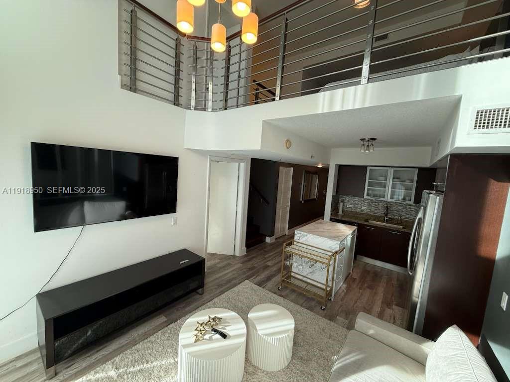 41 Southeast 5th Street, Unit 708 Miami, FL 33131 - Photo 4 of 29 a living room with furniture and a flat screen tv