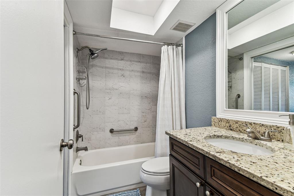 3745 Teeside Drive, Unit 3745 New Port Richey, FL 34655 - Photo 16 of 34 a bathroom with a granite countertop sink toilet and shower