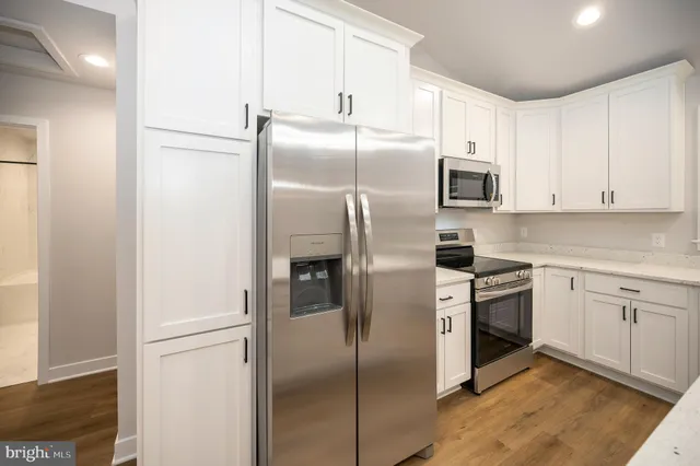 a kitchen with stainless steel appliances granite countertop a refrigerator and a sink