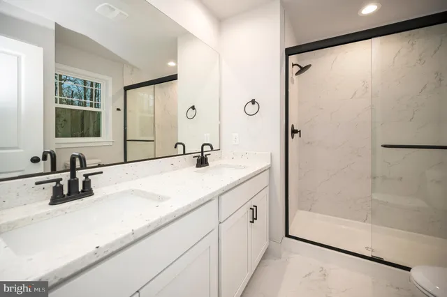a bathroom with a double vanity sink mirror and shower