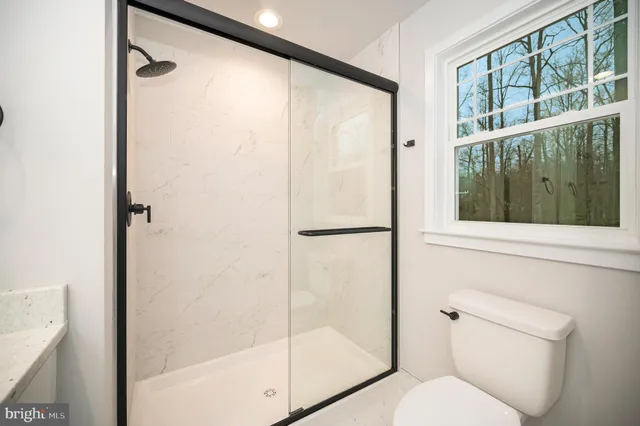 a bathroom with a toilet and a shower