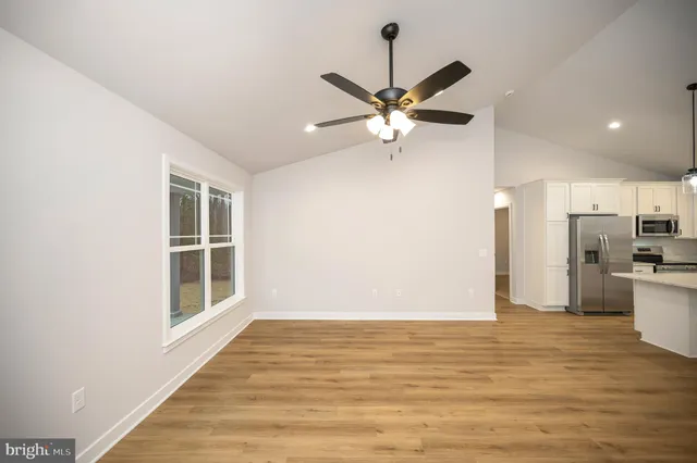 a view of a livingroom with a ceiling fan window and wooden floor