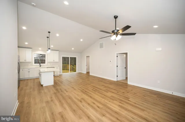 a view of an empty room and window with wooden floor