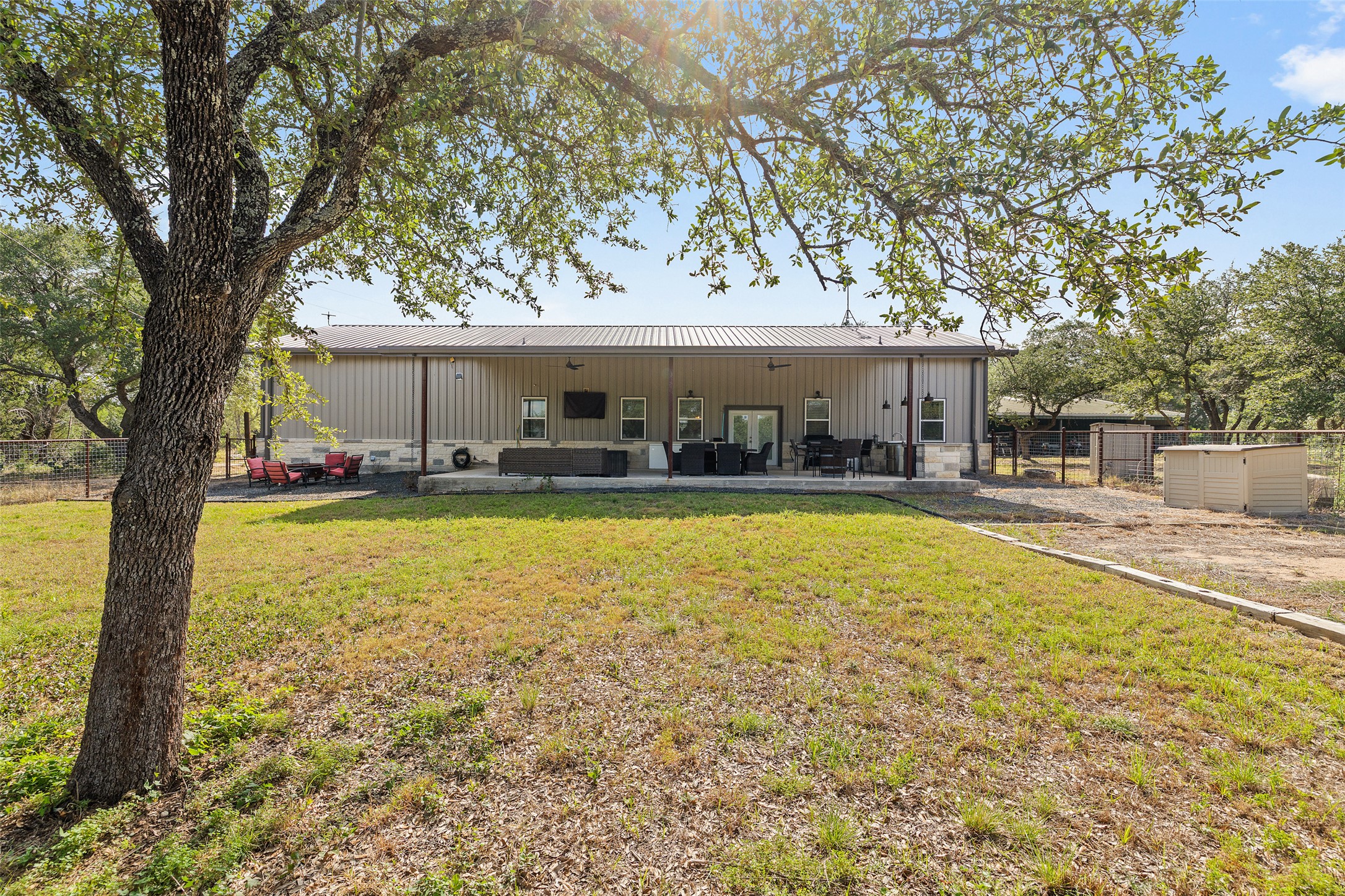 764 Stubbs Road Johnson City, TX 78636 - Photo 11 of 29 A spacious covered patio invites relaxation, offering ample room for outdoor entertainment and dining.