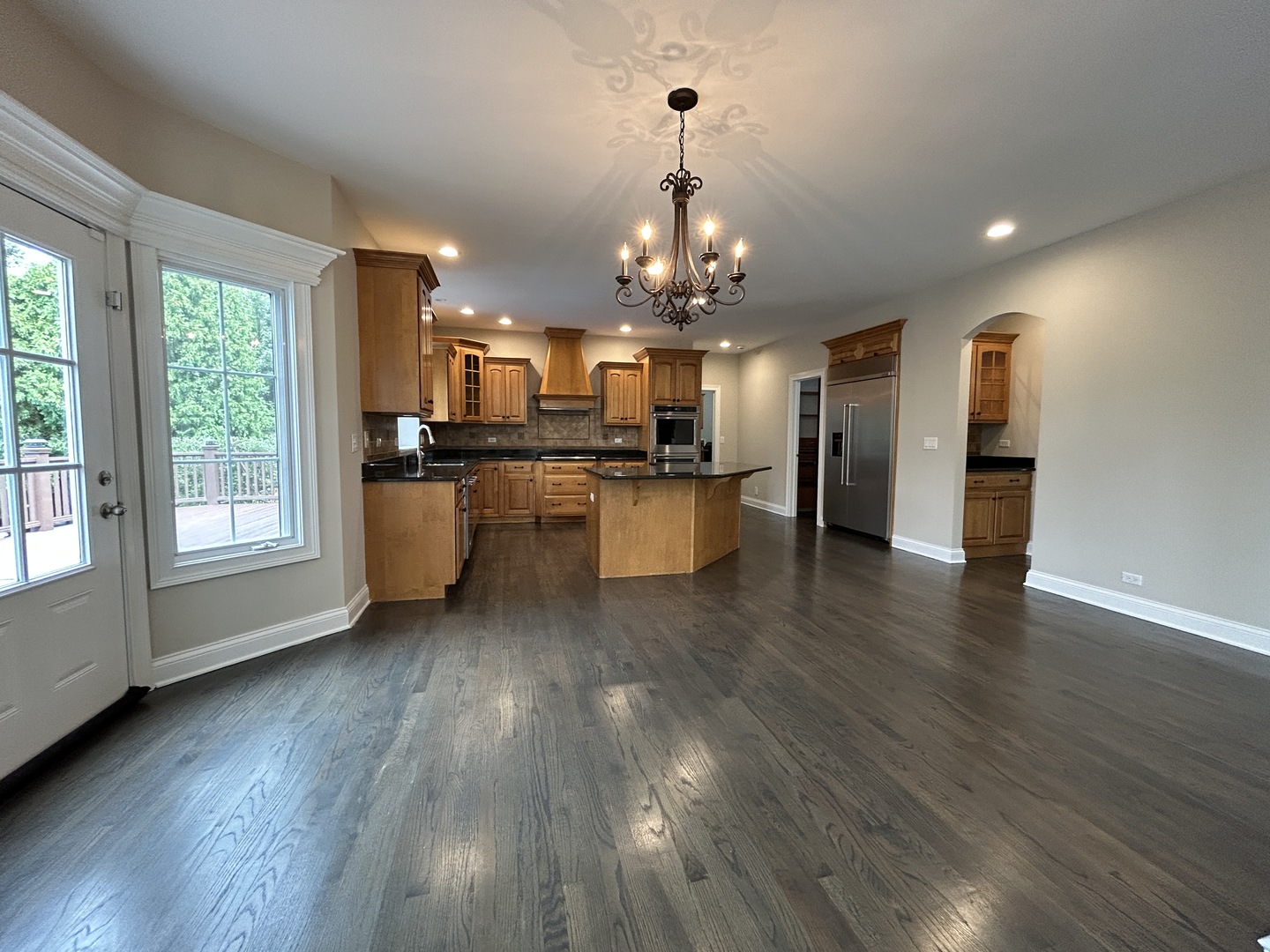 3932 Bluejay Lane Naperville, IL 60564 - Photo 12 of 50 a view of a living room and kitchen with wooden floor and chandelier