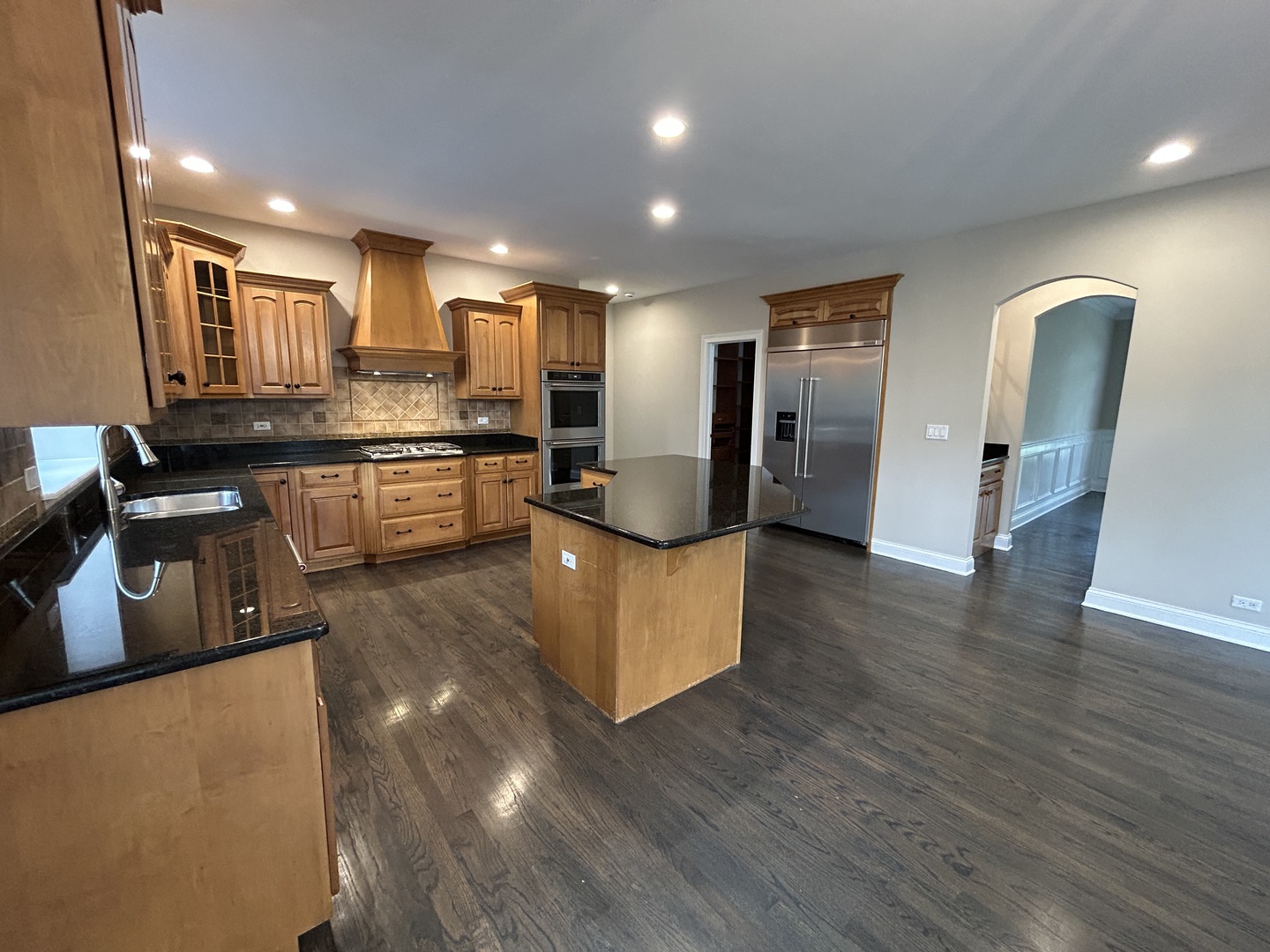 3932 Bluejay Lane Naperville, IL 60564 - Photo 14 of 50 a large kitchen with stainless steel appliances granite countertop a refrigerator a sink dishwasher a stove and a dining table with wooden floor