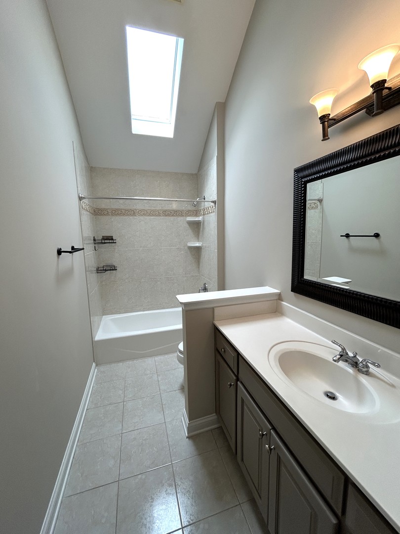 3932 Bluejay Lane Naperville, IL 60564 - Photo 36 of 50 a bathroom with a sink a vanity a mirror and a bathtub