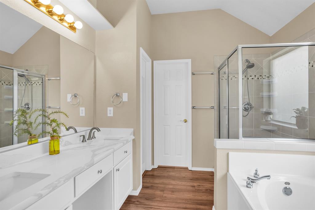 8308 Spring Ridge Drive Plano, TX 75025 - Photo 13 of 28 Dual basin vanity with white cabinetry, a spacious mirror, and a glass-enclosed shower with tile surround