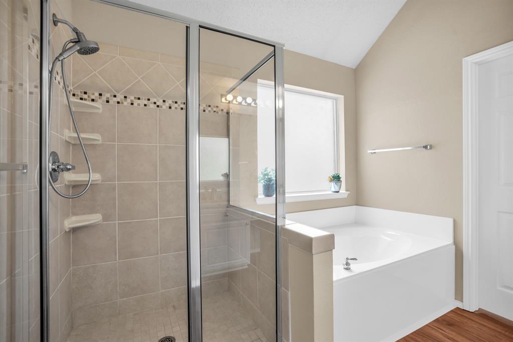 8308 Spring Ridge Drive Plano, TX 75025 - Photo 15 of 28 Glass-enclosed shower with tiled walls and a built-in bench