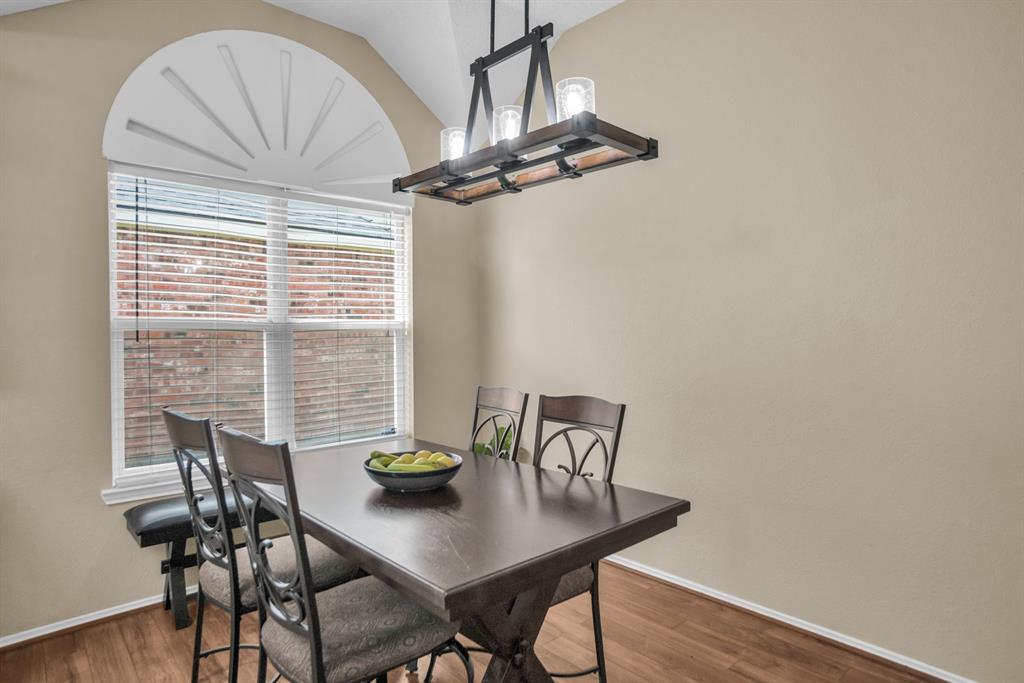8308 Spring Ridge Drive Plano, TX 75025 - Photo 8 of 28 Dining area with a cathedral ceiling, wood-finish flooring, and neutral wall paint