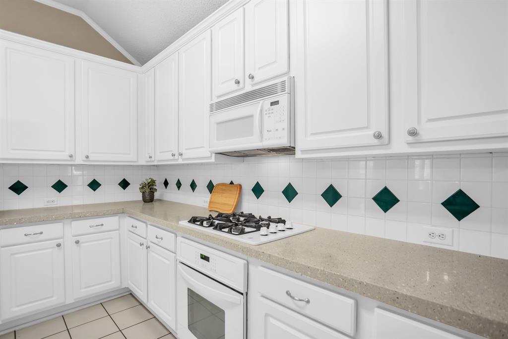 8308 Spring Ridge Drive Plano, TX 75025 - Photo 10 of 28 Kitchen featuring white cabinetry, light-toned countertops, a built-in gas range, coordinating wall oven, and microwave