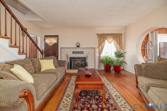 a living room with furniture fireplace and potted plants