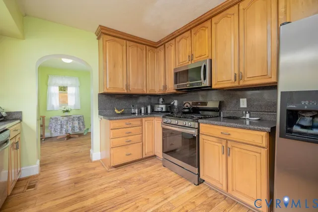 a kitchen with stainless steel appliances granite countertop a stove a sink and a microwave