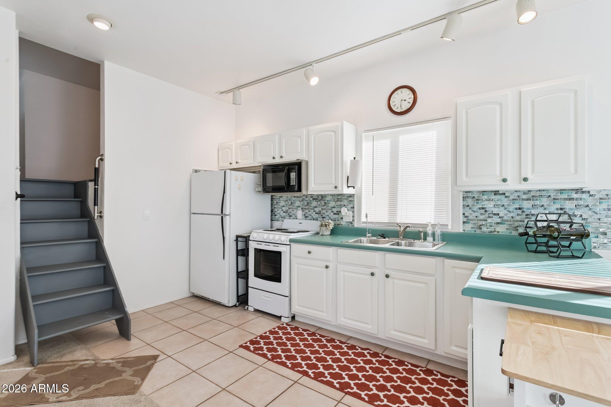 17200 West Bell Road, Unit 869 Surprise, AZ 85374 - Photo 13 of 25 a kitchen with white cabinets and white appliances
