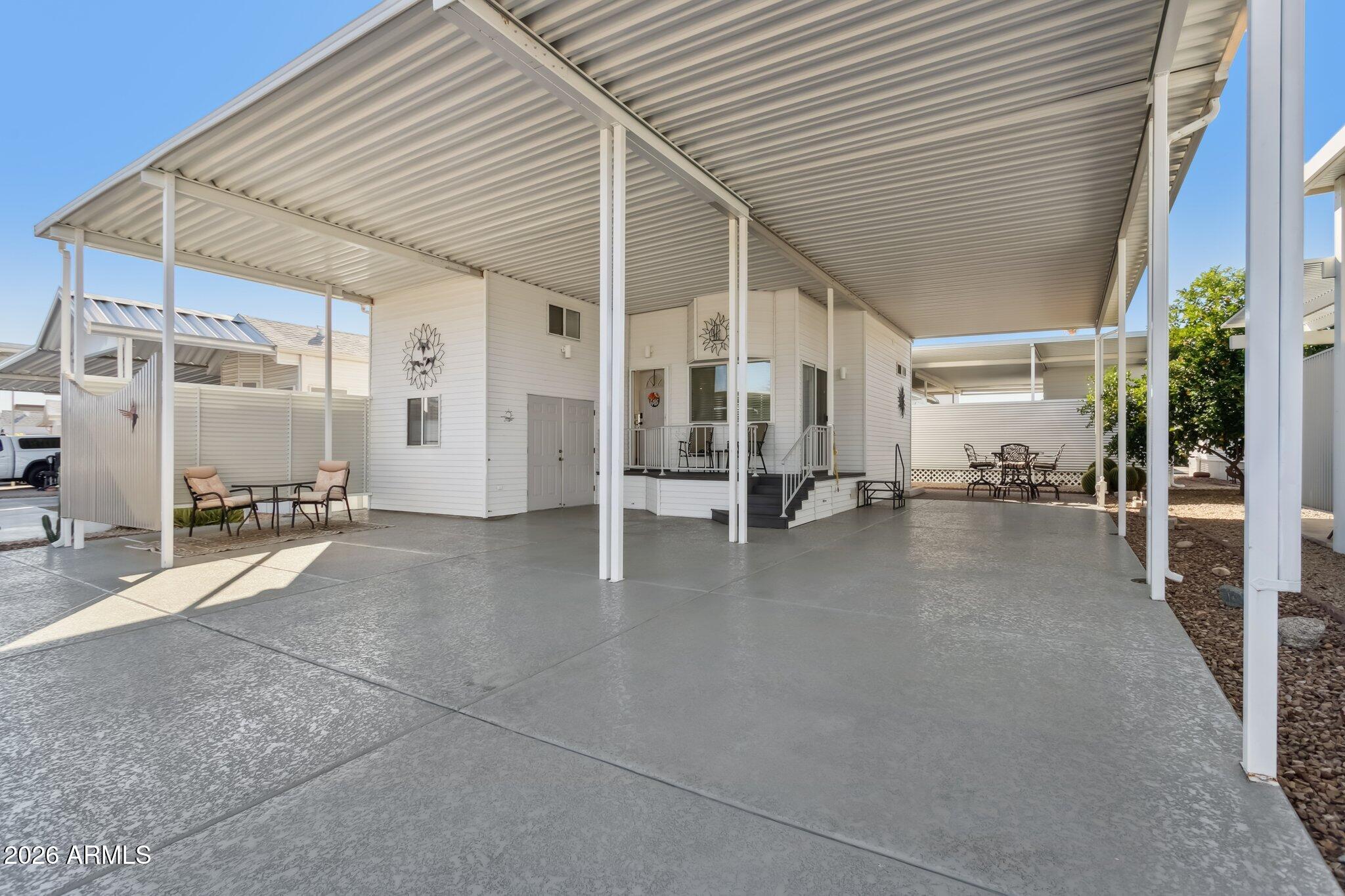 17200 West Bell Road, Unit 869 Surprise, AZ 85374 - Photo 3 of 25 a view of a patio with table and chairs and potted plants