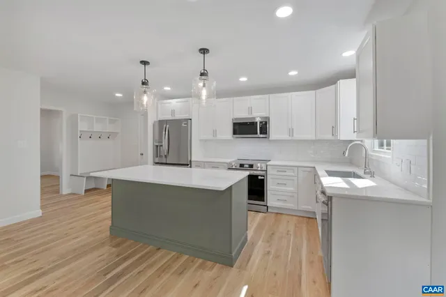 a large kitchen with stainless steel appliances granite countertop a lot of counter space and wooden floors